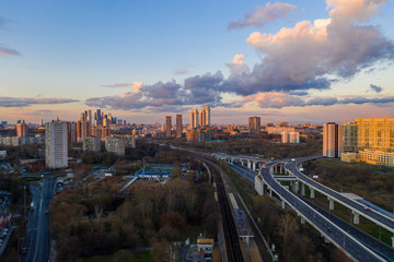 Fototapeta na wymiar panoramic view with skyscrapers and motorways of a big city at sunset shot from a drone