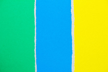 Blue, green and yellow ripped pieces of cardboard paper texture background. Copy space for text message.