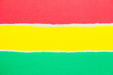 Red, yellow and green torn sheet of cardboard paper texture background. Copy space for text message.
