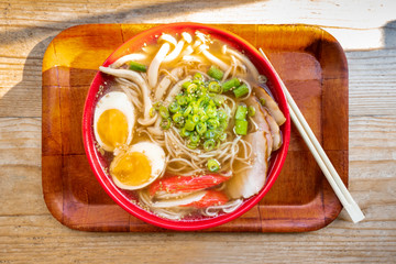 Tonkotsu ramen close-up, shot above, with eggs, scallions and mushrooams, with chopsticks on a tray