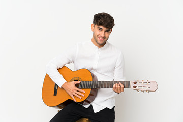 Obraz premium Young handsome man with guitar over isolated white background