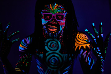 portrait of young unrecognizable man in sunglases with fluorescent prints on skin, cool handsome fashionable guy posing at camera
