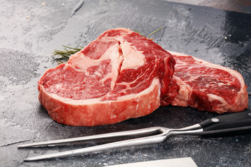 Steak. Two fresh raw rib-eye steak with rosmary in a rustic style table