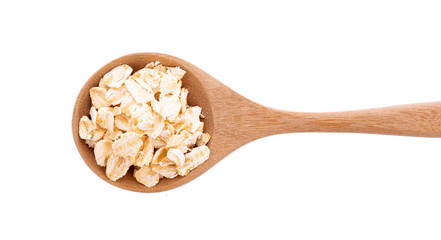 Oat flakes pile in wooden spoon on white background