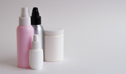 Bottles with tablets in white, pink, gray on a gray background. Copy space