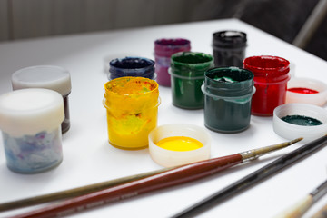 Acrylic paints, brushes and palette knife on the white canvas. A process of painting. Hobby. 