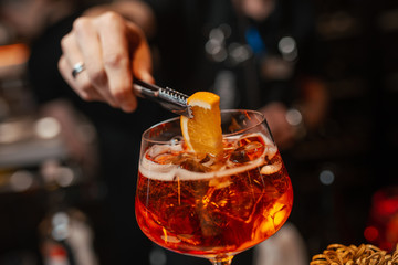 The bartender is preparing an Aperol Spritz cocktail. Close-up