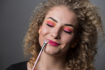 Obraz premium Beautiful young girl with colourful makeup. Make up, crazy hairstyle, lipstick, eye shadows, hair. 