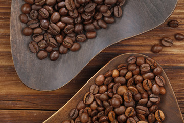 Coffee beans of different roasting in wooden plates. Top view. Coffee beans on a wooden background. 