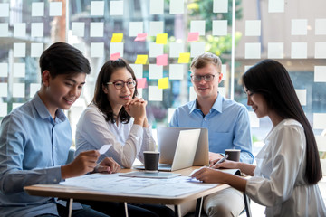 Teamwork of young asian business people meeting to discuss and plan collaboration.