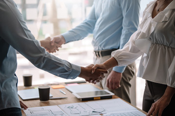 Teamwork of business people at meeting shaking hands to seal a deal with his partner.