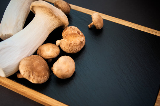 shiitake and eringi mushrooms on black background