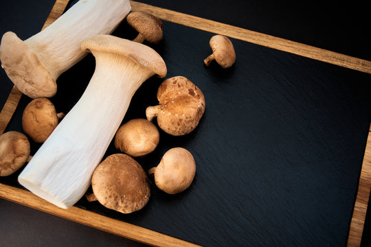 shiitake and eringi mushrooms on black background