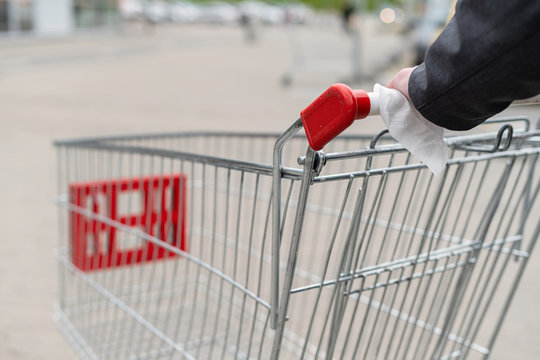 Man Cleaning Handle Of Shopping Cart, Trolley Using Antivirus Antibacterial Wet Wipe (napkin) For Protect Himself From Bacteria And Virus. Grocery Store, Supermarket