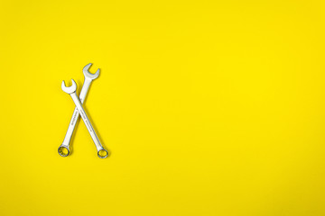 Two wrenches on a yellow background