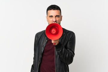 Young man over isolated white background shouting through a megaphone