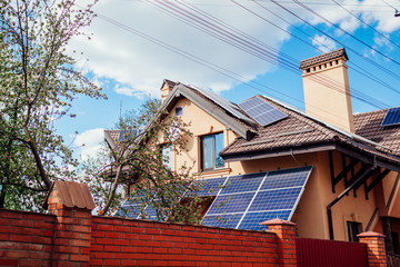 Residential house with solar panels on roof. Alternative energy. Using sun power for home. Conservation