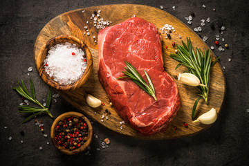 Fresh beef steak on black table.