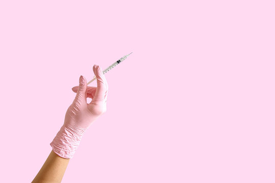 Female hand in a glove with a hypodermic syringe