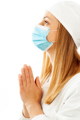 Portrait of a female doctor praying wearing a mask