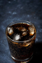 glass of coca cola with ice on a dark background, top view