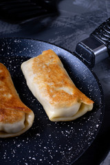 Pancakes with filling roasted on the pan - 343173578