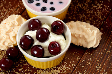 yogurt with cherry fruit, cookies and wafers on scattered sugar