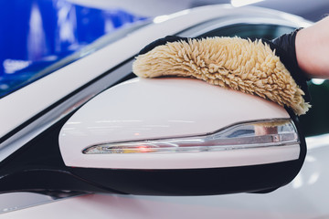A man cleaning car with microfiber cloth, car detailing or valeting concept. Selective focus.