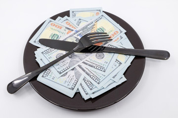 Plate full hundreds of dollar bills with fork and knife. Concept of prosperity and abundance. Full plate concept. Copy space