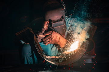 Welding steel structures and bright sparks in steel construction industry. Blue tone