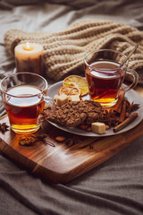 Hot spicy tea in bed with chocolate cookies cinnamon lemon and sugar