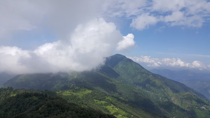 Watching the mountain top from another top with clouds and sunshine