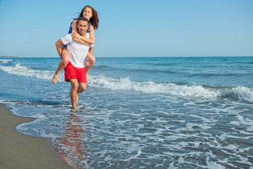 Fototapeta na wymiar Young happy couple on seashore 