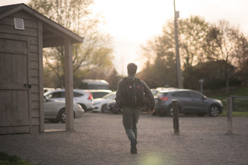 Photographer running toward the sun in a parking lot at sunset