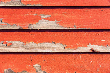Close up view at part of typical small red colored guest house with white window at Swedish country side needs immediate renovation - old paint flake off, boards starting to be rotten