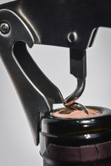 Bottle of wine and corkscrew close up, spiral is entering the cork, opening the bottle. Selective focus.