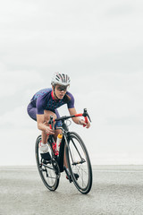 Isolated female road cyclist cycling fast - obrazy, fototapety, plakaty