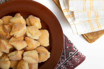 Crispy cottage cheese cookies lies on a brown plate