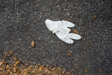 Closeup of used latex glove abandoned in the street - 343179162