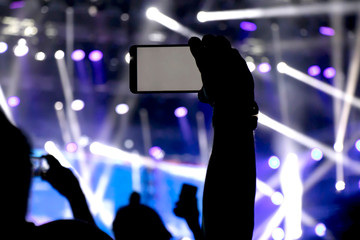  Silhouette of a person hand shooting the concert with his smart phone