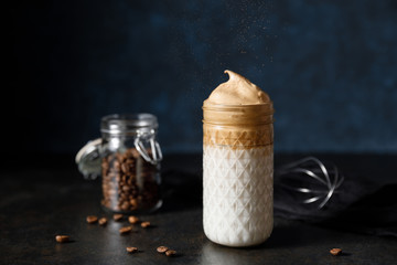 The Korean coffee drink dalgona on dark wooden background