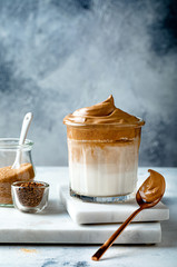 Dalgona coffee. Whipped trend drink with coffee foam and milk. Trendy drink during Covid-19 city lock down and self quarantine, stay at home concept.