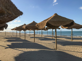 Umbrellas on the beach, private area of the hotel resort, relaxing peacefull sunbath on the sea side, isoleted with distanse during quarantine, loss period