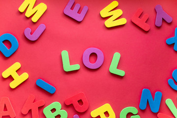 Abbreviation LOL From Plastic Magnetic Letters On Red Background