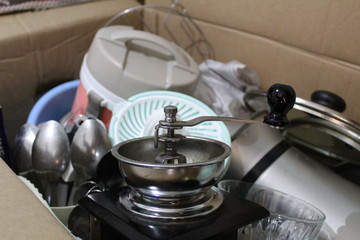coffee grinder and kitchen utensils in a box assembled for moving