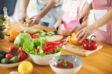 Fotobehang Family cooks fresh vegetables on the table in the kitchen. © Studio Romantic