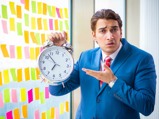 Young handsome employee with many conflicting priorities