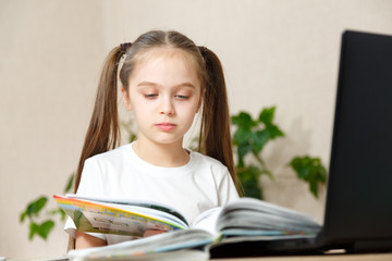 Little Cute Cheerful girl, 9-10 Years Old, Second Grader, Does Homework at The Table, at Her Desk, a Lot of Textbooks, Blonde