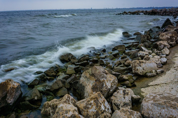 Fototapeta na wymiar Landscape with waves crashing against the coastal stones at sunrise.