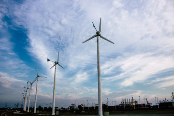 Chon buri, Thailand - 24 April 2020. Wind turbines provide electric power. In the electricity generation industry of Thailand. Wind Turbines Windmill Energy Farm and blue sky with. Container Terminal.